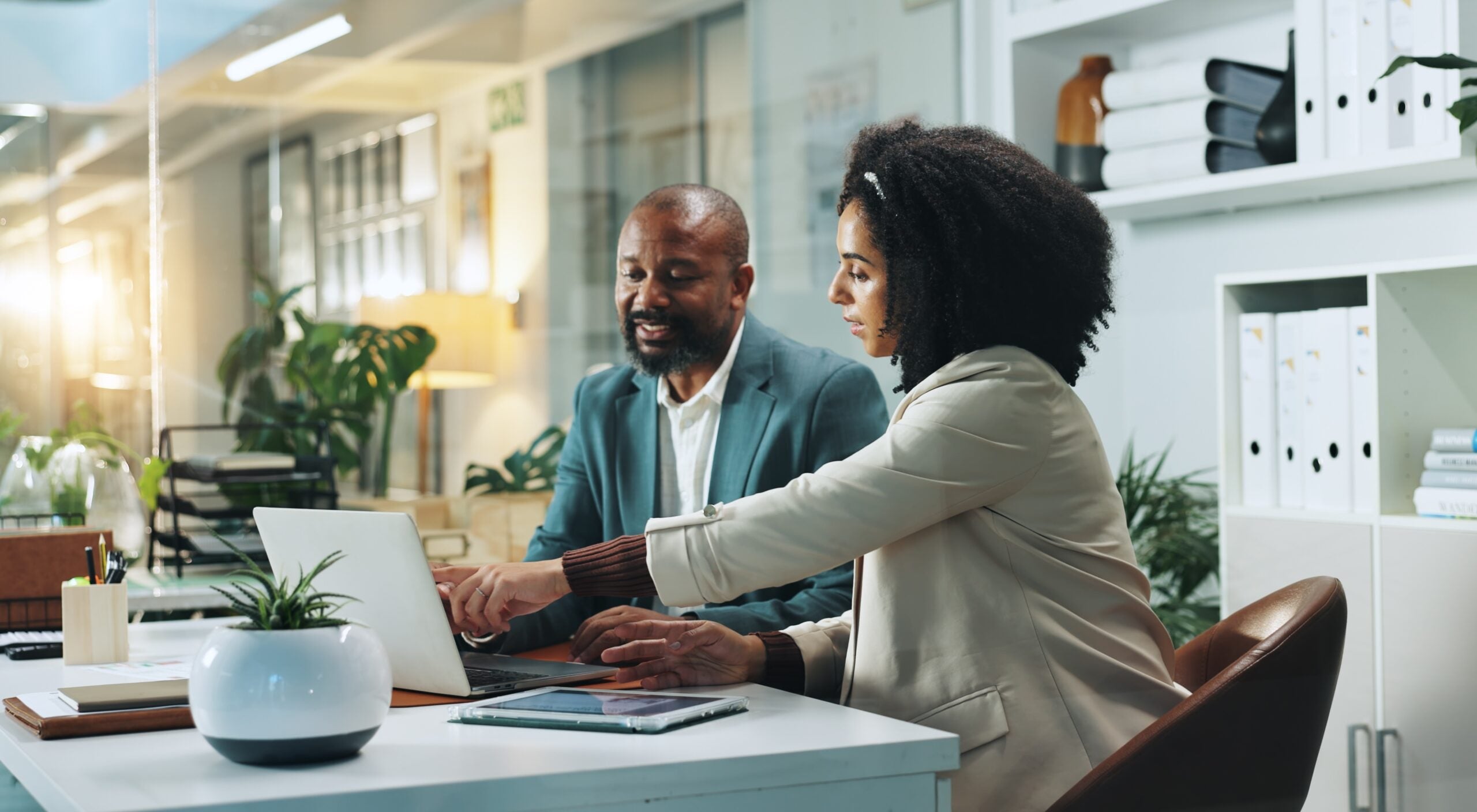 Laptop, business people and team planning in office for insurance, meeting or idea at night. Computer, collaboration and happy African workers with feedback, solution and help with policy on overtime